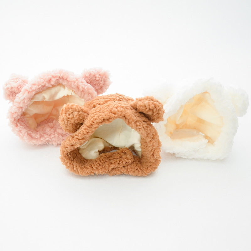 Three fluffy cat ear hats in pastel pink, caramel brown, and white. Each hat features prominent cat ears on top with a cozy, textured exterior resembling soft fur. The interiors are lined with a smooth, satin-like fabric in lighter shades, creating a comfortable and warm space for wearers. These cute, animal-inspired hats are displayed against a clean, white background, highlighting their cozy and cute design